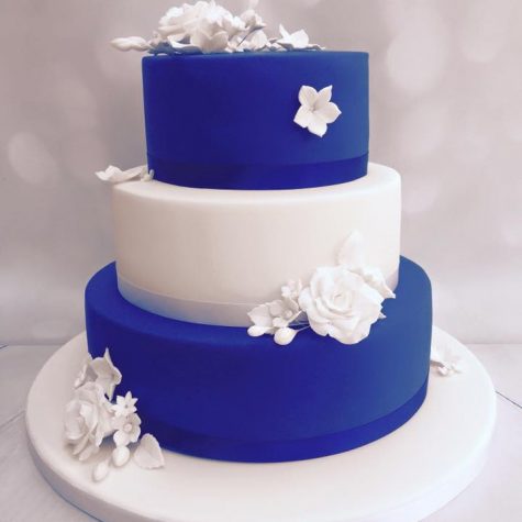 A 3 tier royal blue and white iced, sharp edged wedding cake, with handmade sugar flowers